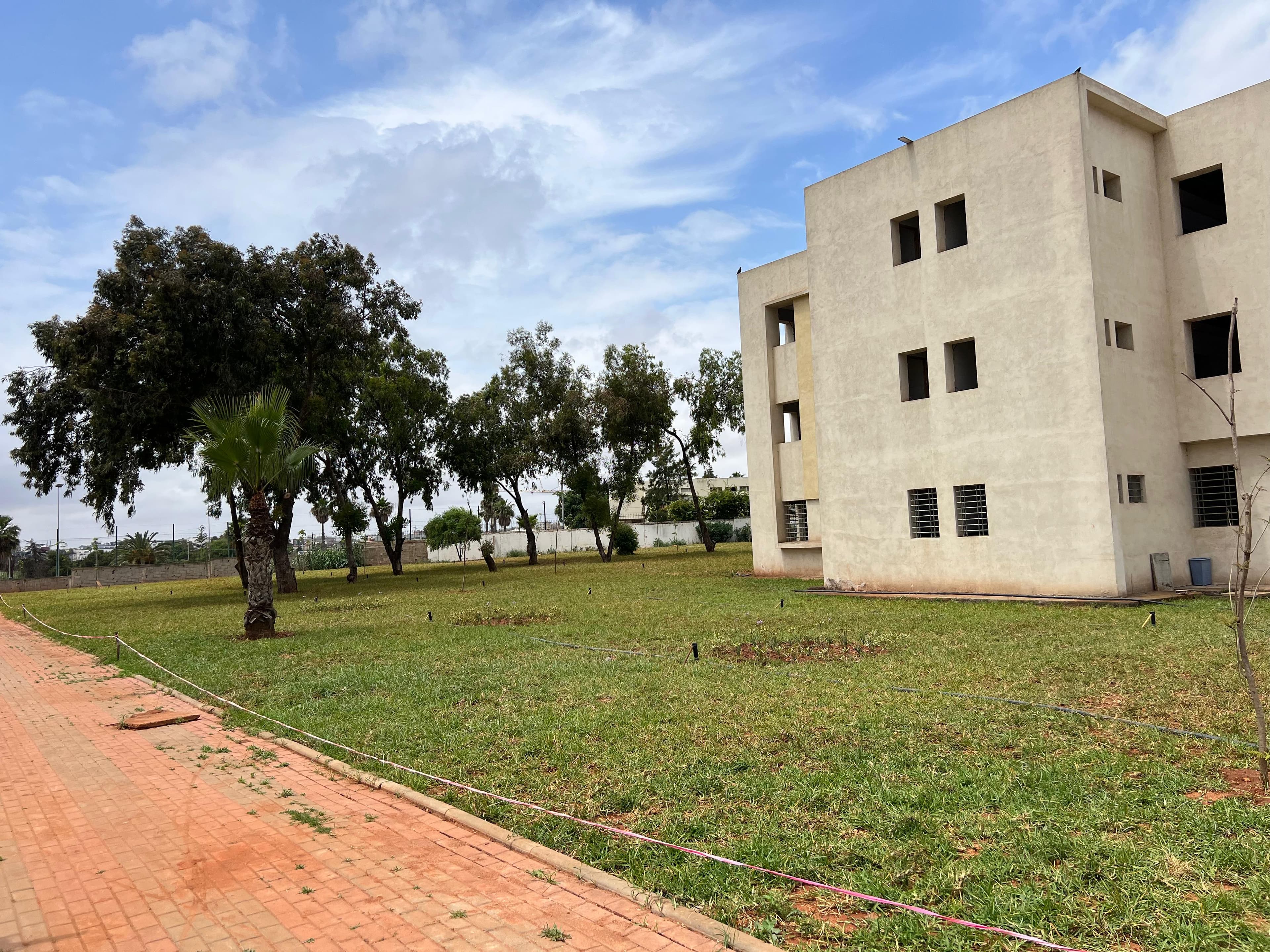 Lush green garden and lawn area on the ENSEM campus.