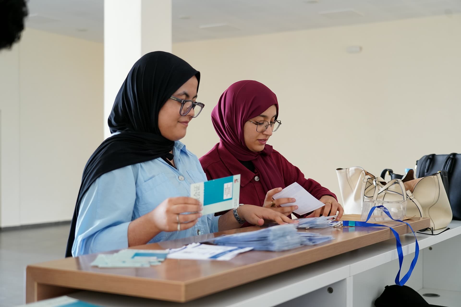 Two volunteers preparing badges and welcome packs at the registration desk.