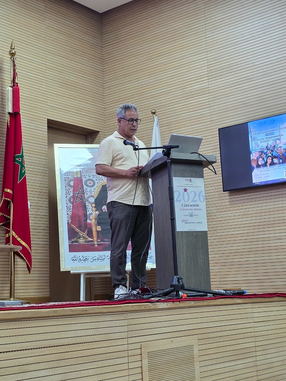 Welcome words from the podium beside the Moroccan flag.