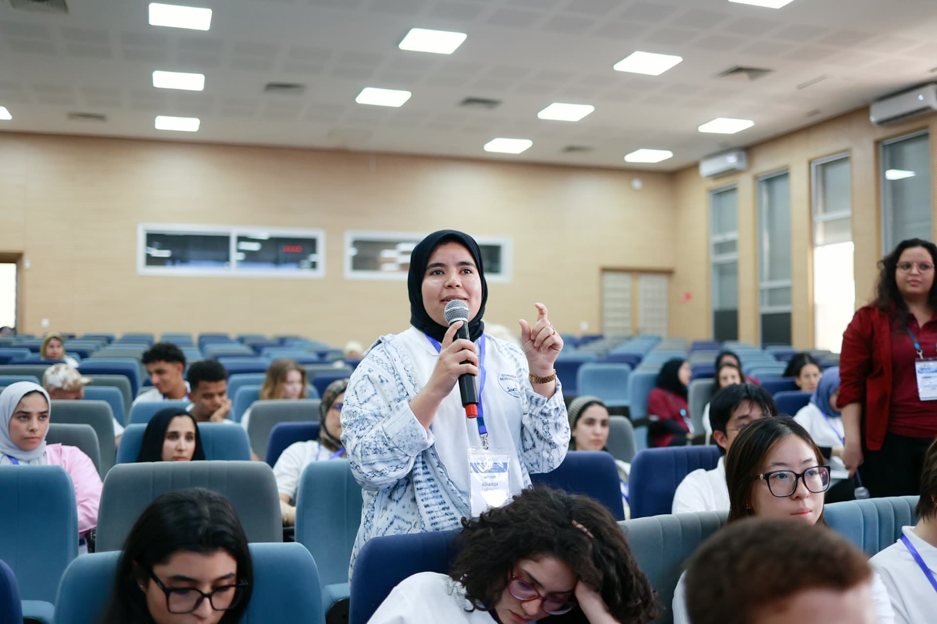 A participant standing with a microphone to ask a question during the Q&A.