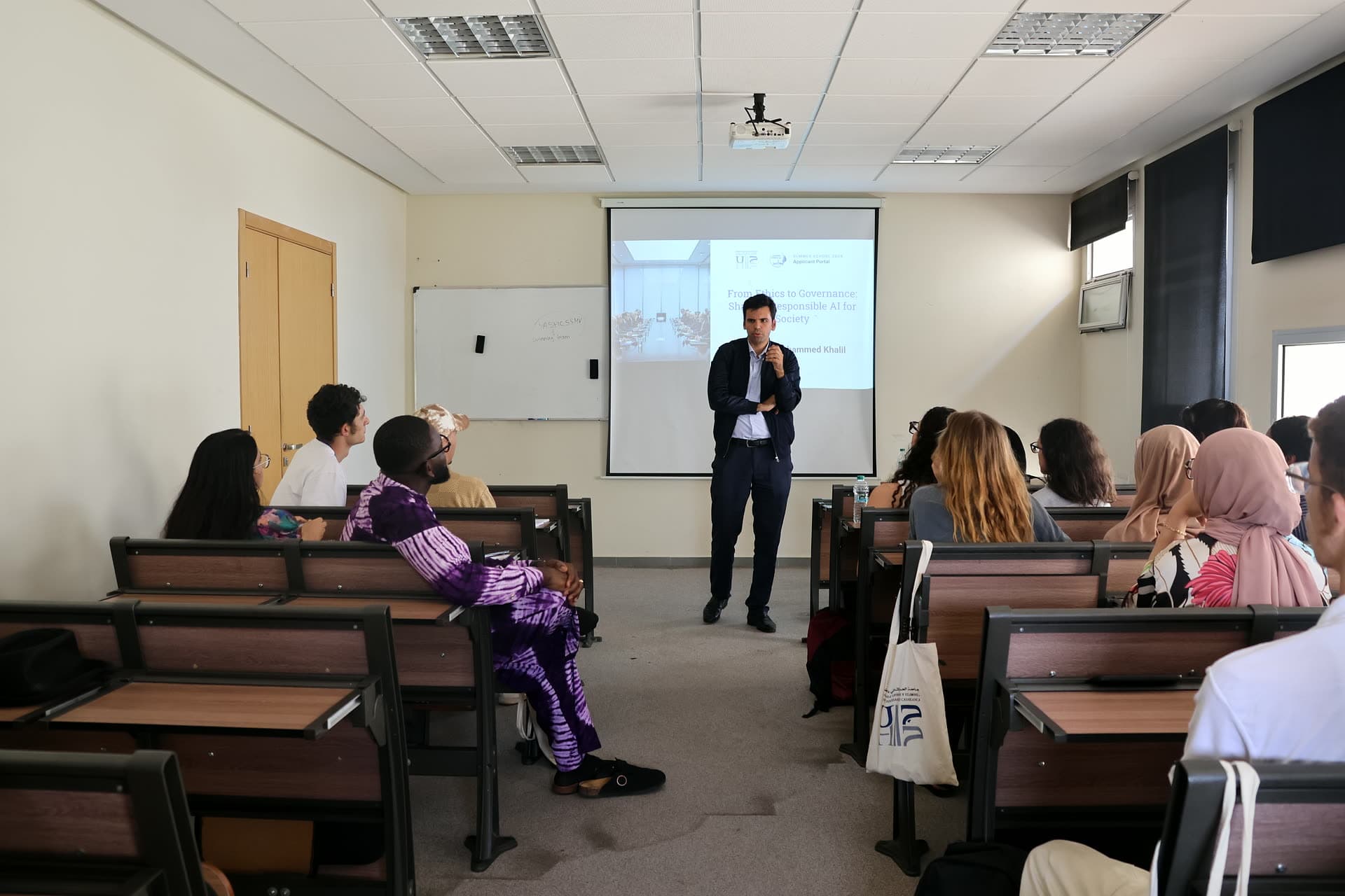 Facilitator presenting in the middle of a classroom during an afternoon coding workshop.