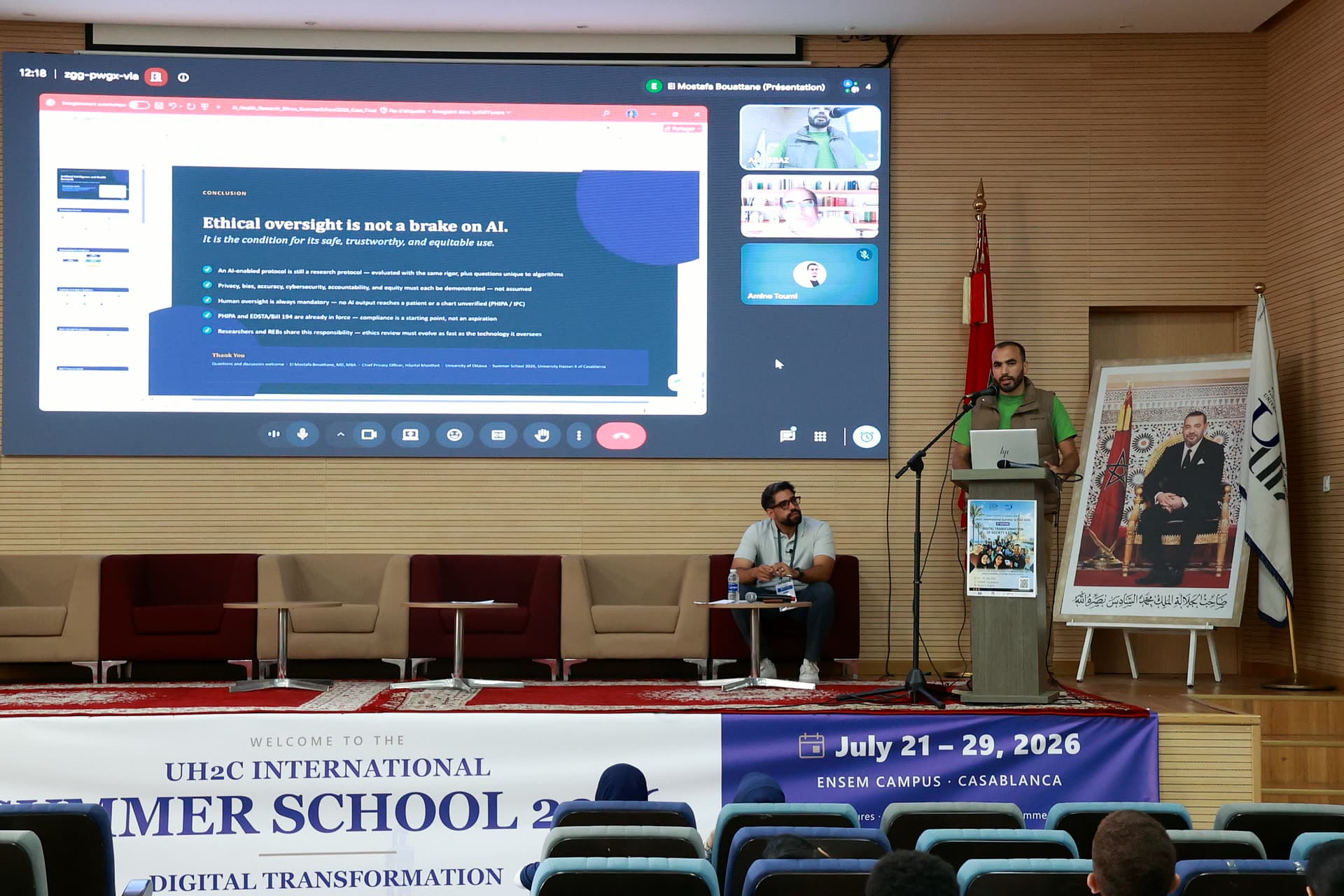 Online lecture on responsible AI shown on the big screen, with the session host at the podium.