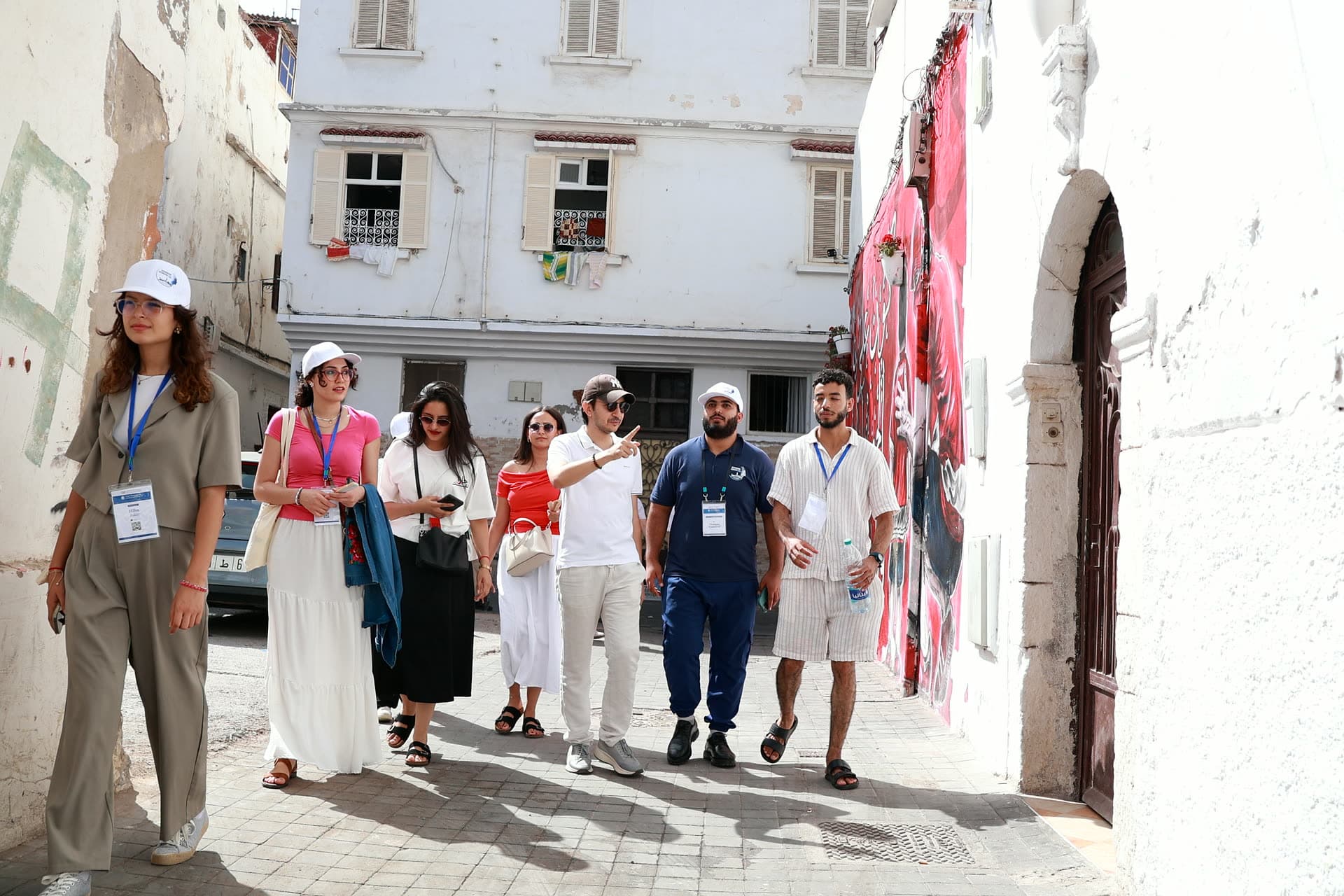 Participants strolling through a whitewashed lane of the old medina.