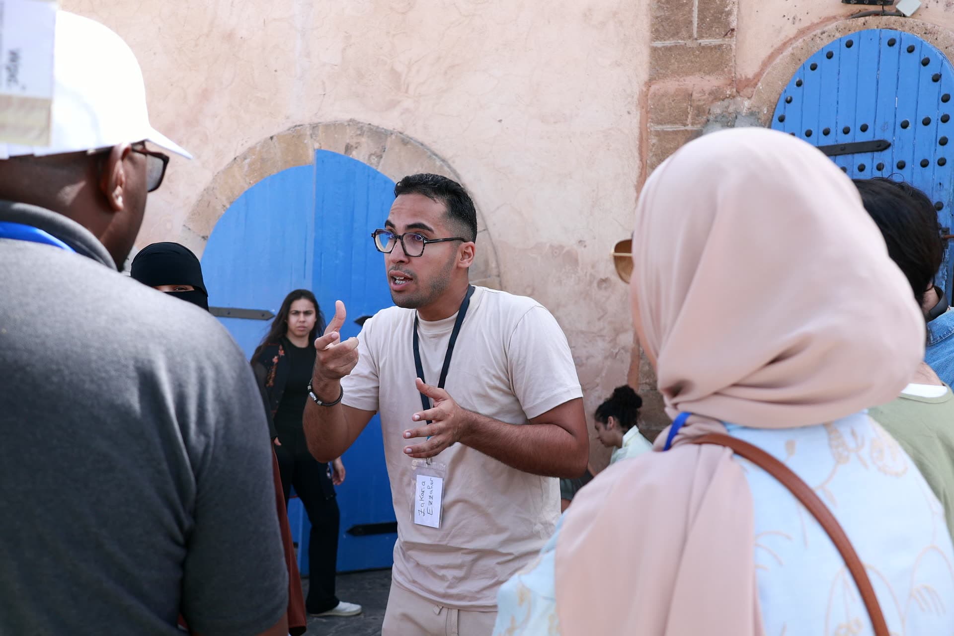 The tour guide mid-story in front of the blue doors of the sqala of Casablanca.