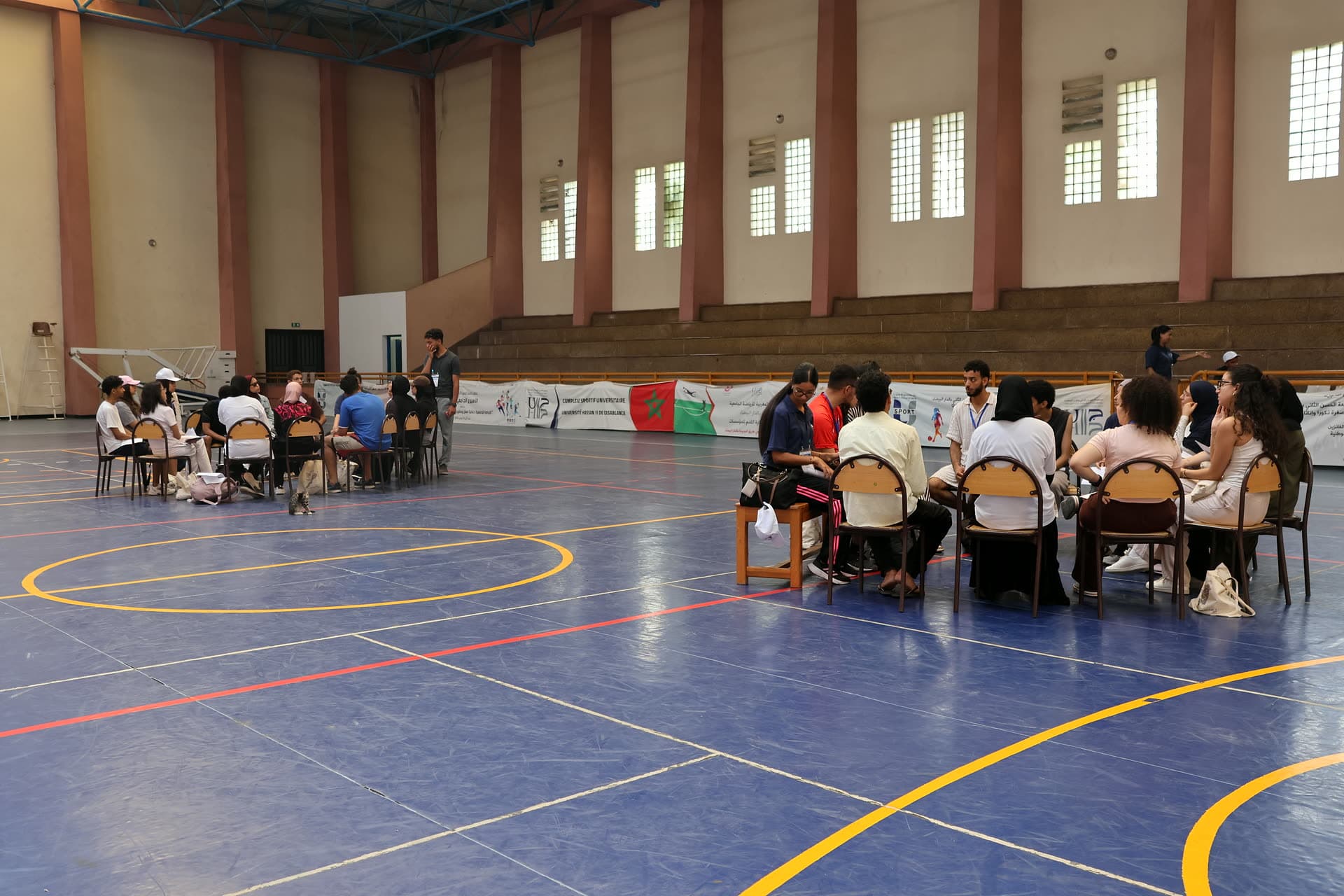 Discussion circles spread across the sports-hall floor during the content-creators meetup.