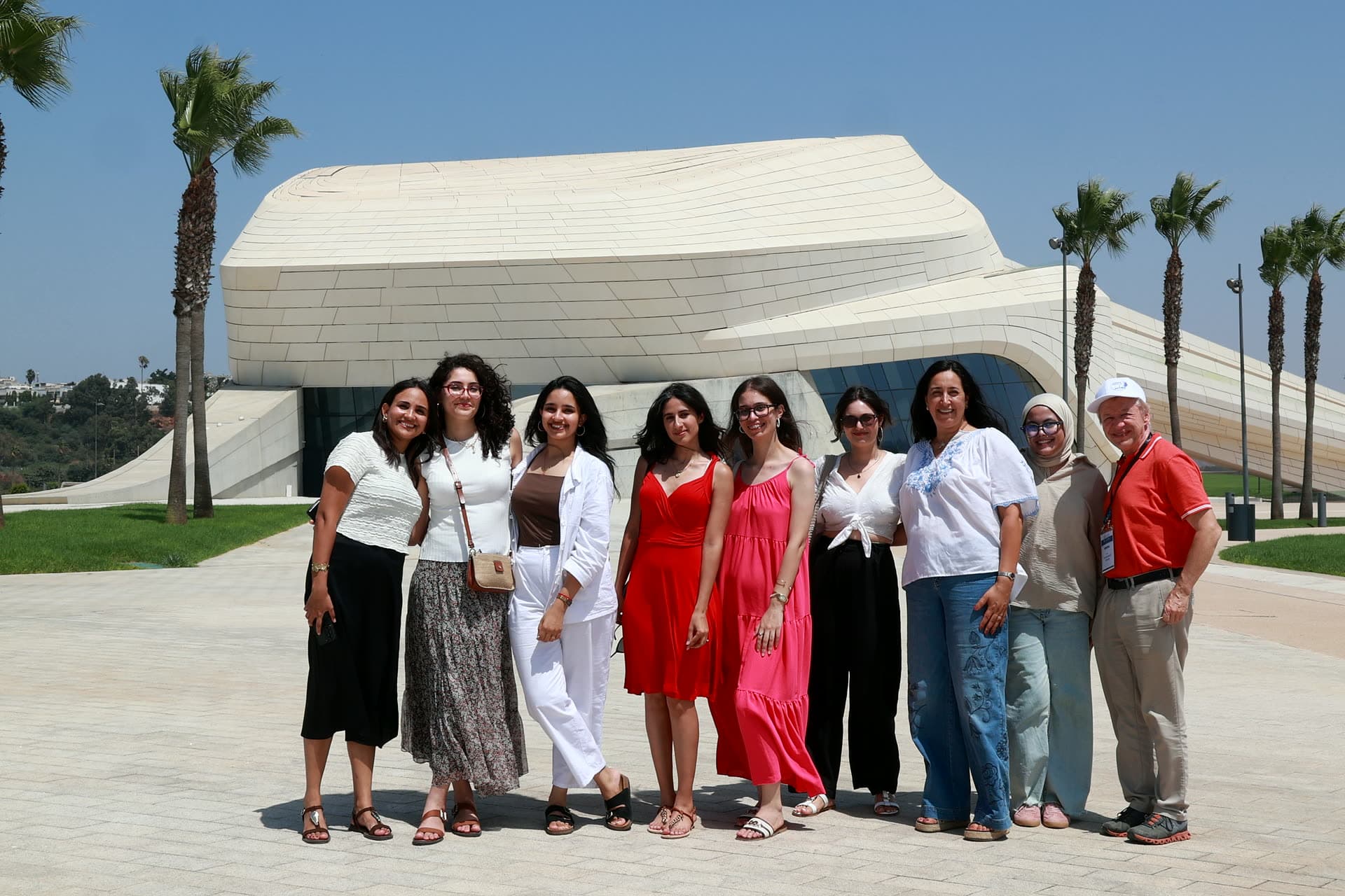 Group posing before the sweeping white curves of the Grand Théâtre de Rabat.