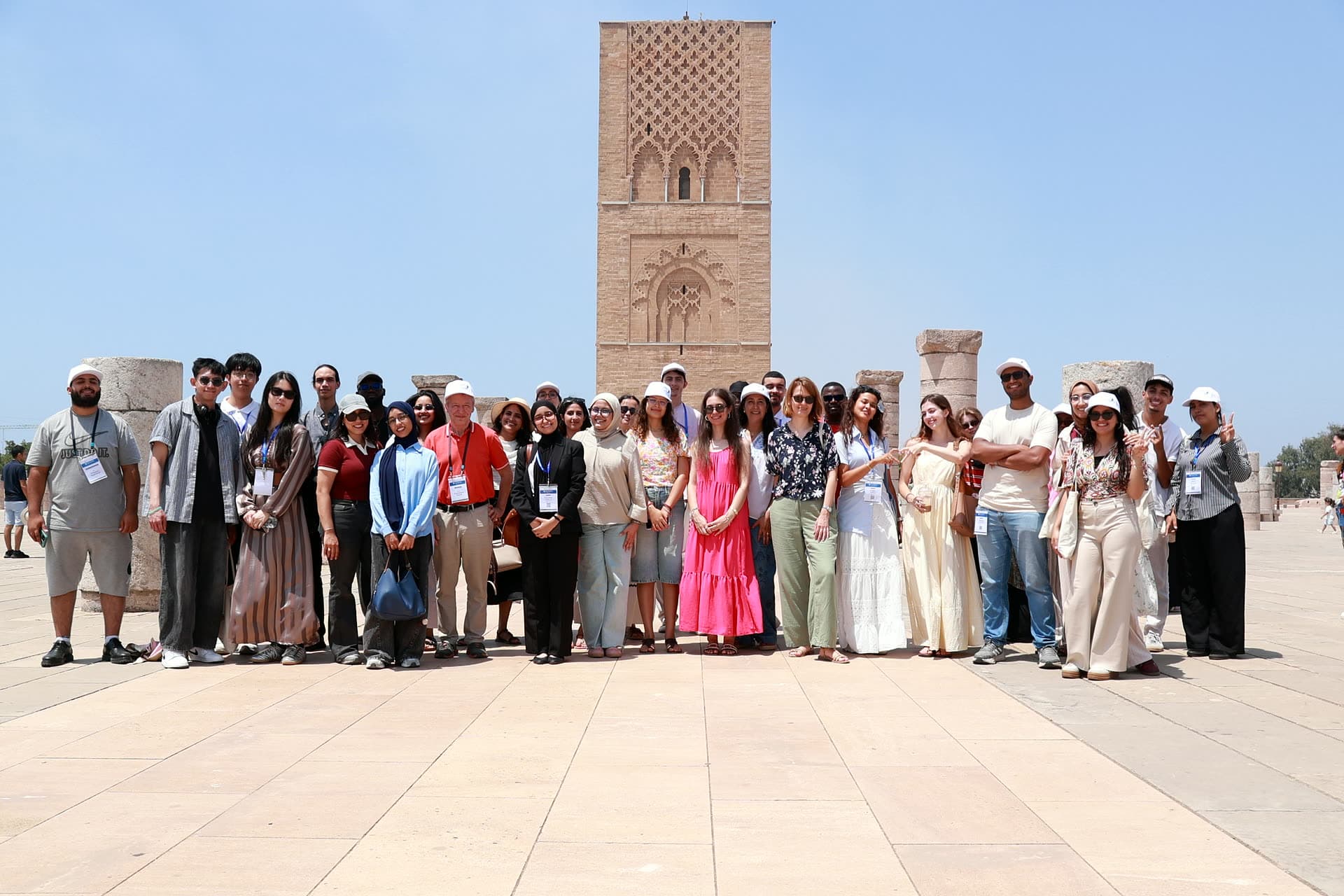 The cohort lined up on the esplanade with the Hassan Tower rising behind them in Rabat.