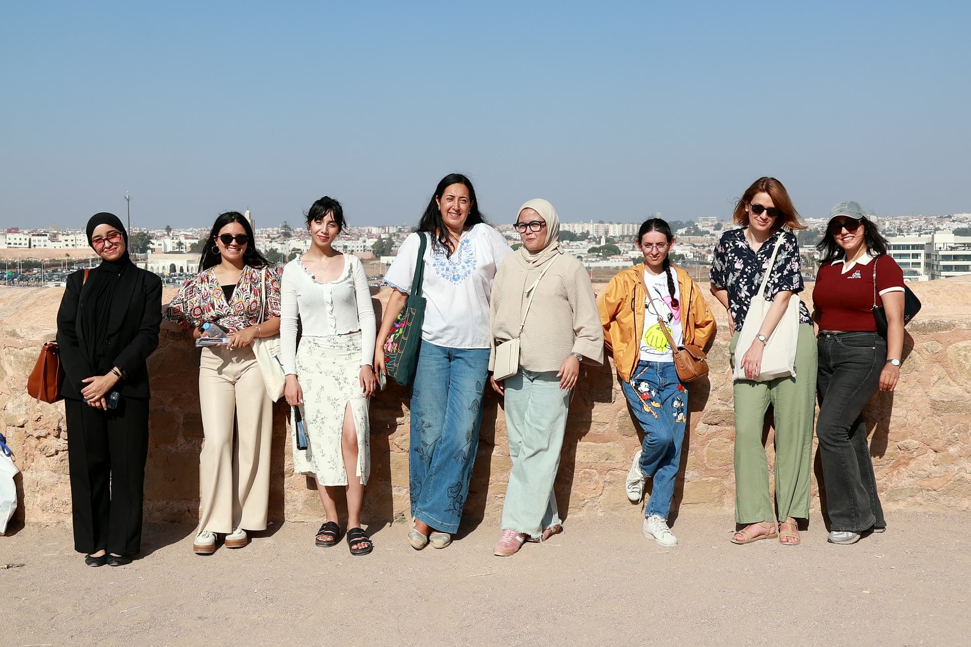 Row of participants on the Oudayas terrace with Rabat and the river behind them.