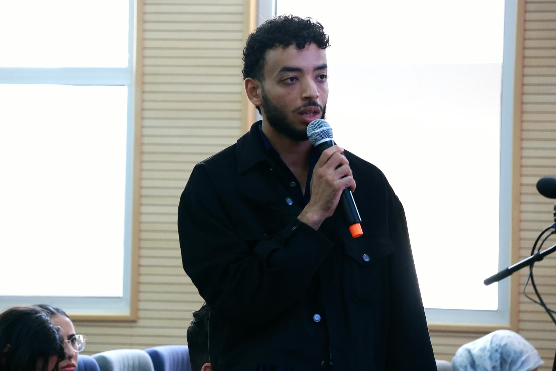 A participant standing with the microphone to ask his question.
