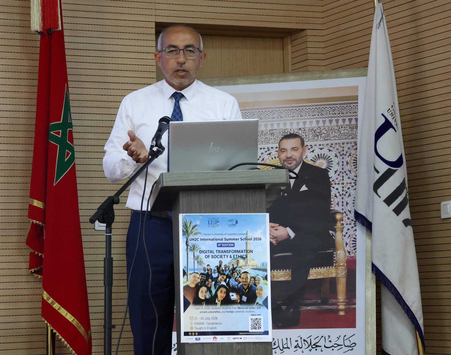 Speaker in shirt and tie delivering a lecture at the podium.