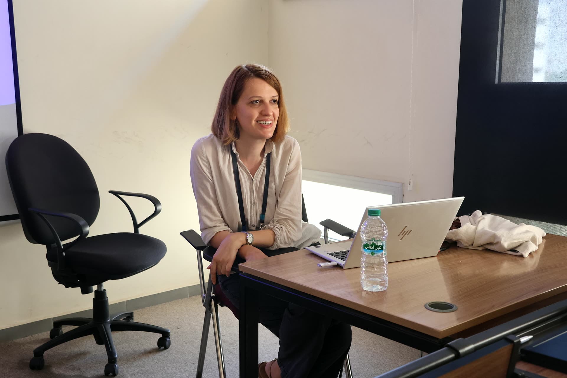 Workshop facilitator smiling at her desk during the afternoon session.