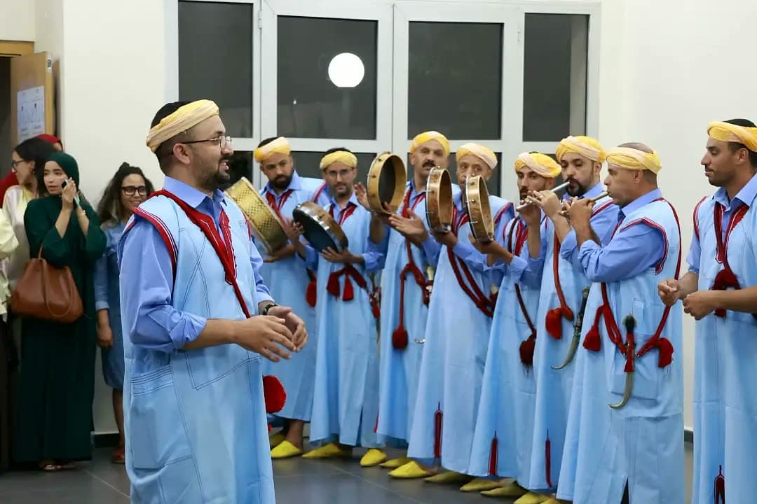 Ahwash ensemble — traditional Amazigh folk musicians and dancers in blue caftans closing the ceremony.