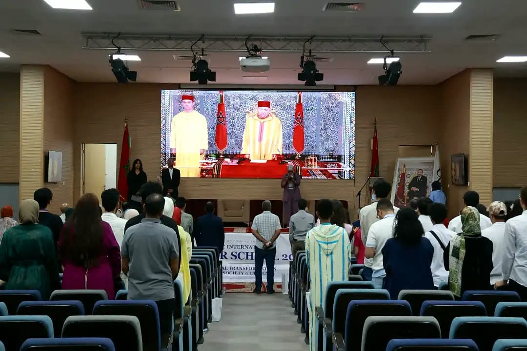 The hall standing for the anthem as the King's Throne Day speech plays on the big screen.