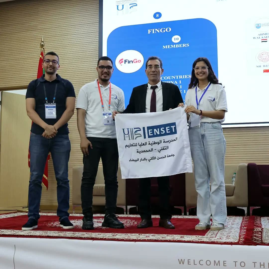 FinGo members holding the ENSET banner with an official.