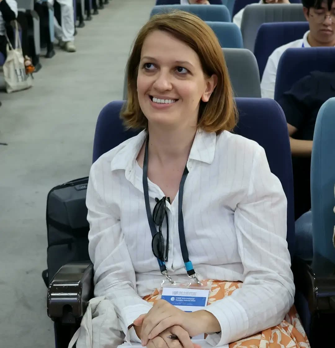 Jury member smiling as she follows the pitches from the front row.