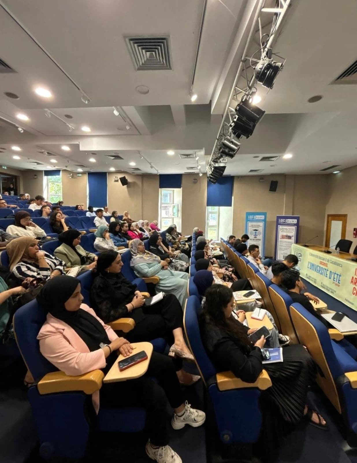 Audience of students taking notes during a 3rd-edition seminar, side view.