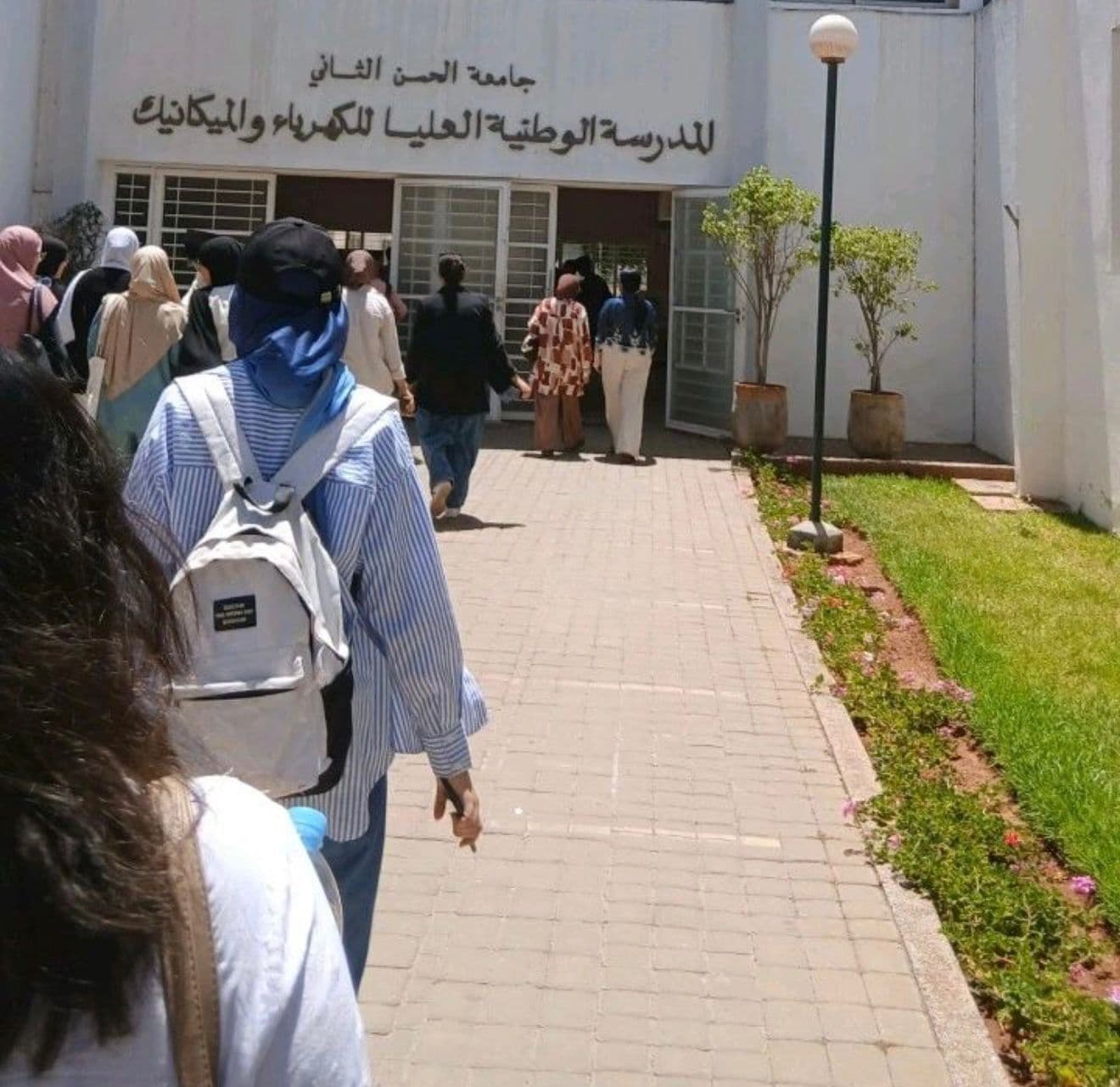 Students walking towards the entrance of ENSEM on the UH2C campus.
